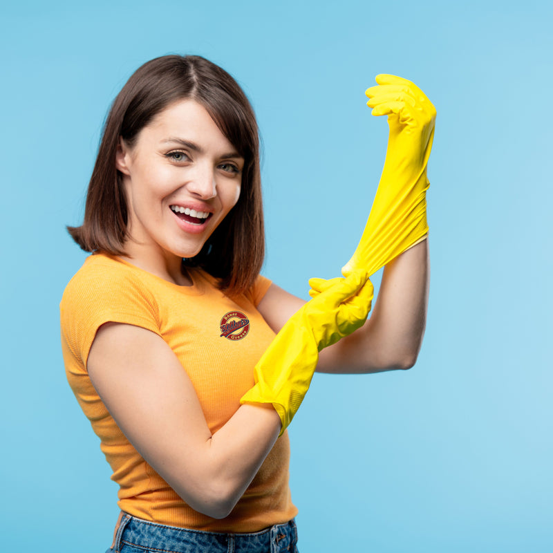 Woman putting on large yellow rubber glove.